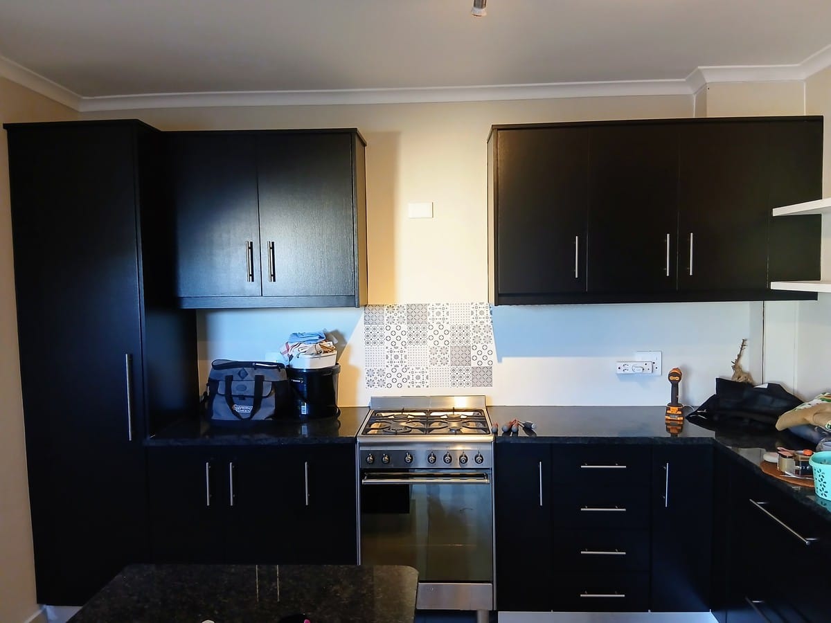 Kitchen cupboards in Macassar finished in a uniform dark coat